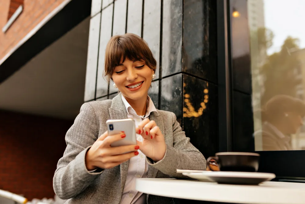 Small business owner reviewing marketing on her phone at a cafe